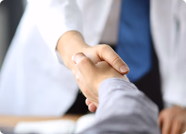 Doctor and patient shaking hands during a medical consultation.