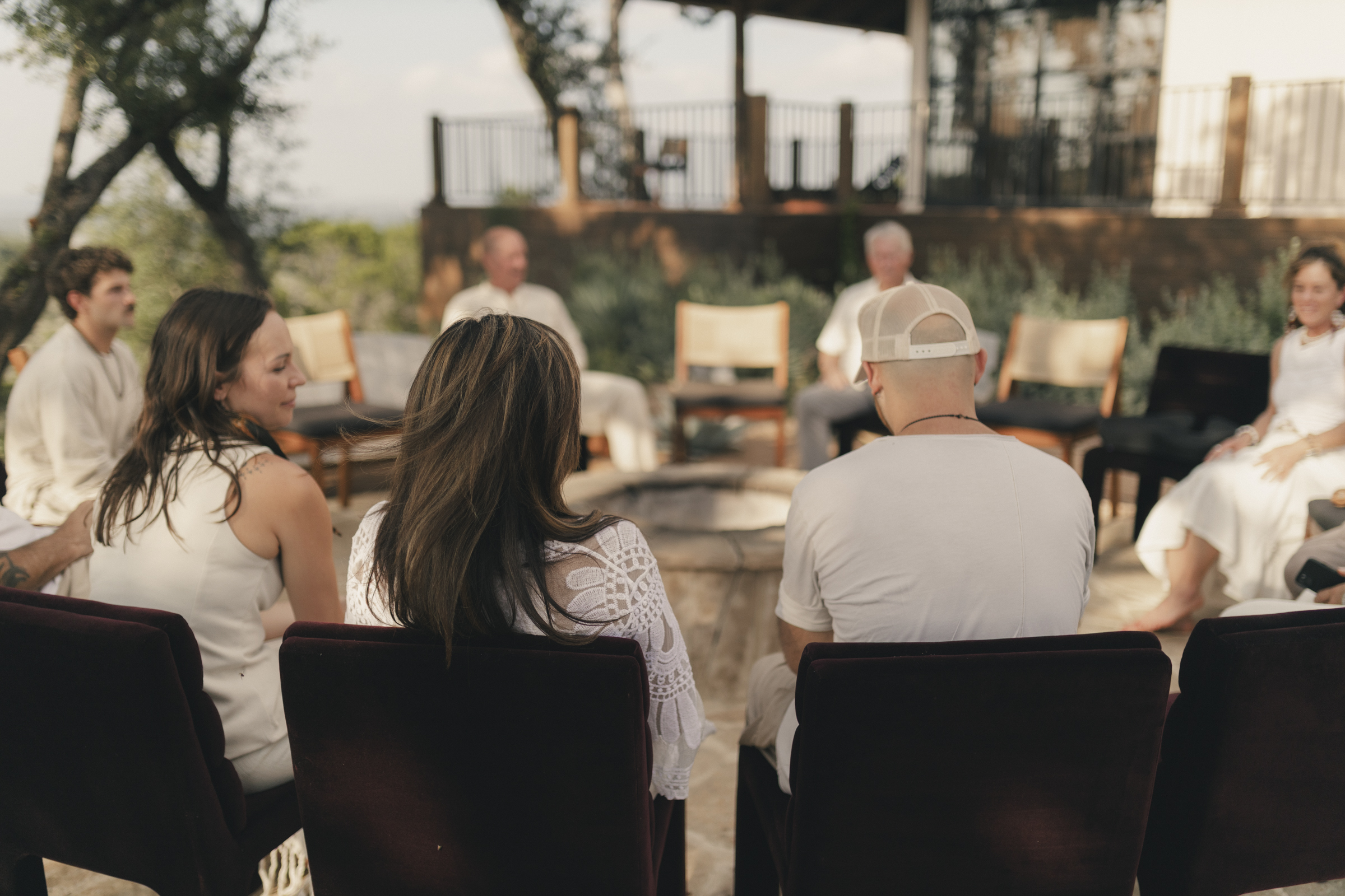 Retreat participants sitting in a circle on an outdoor patio