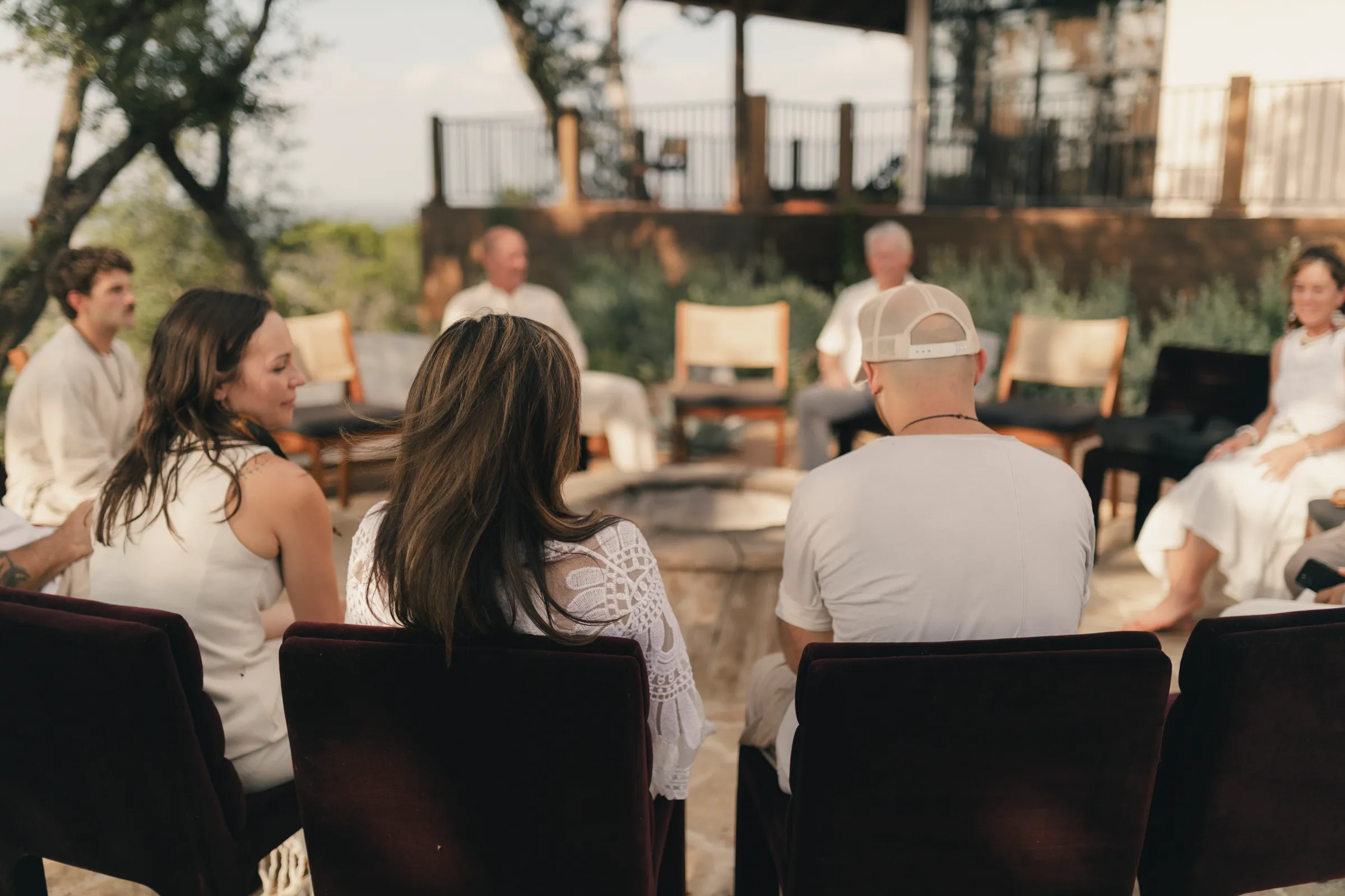 Retreat participants sitting in a circle on an outdoor patio