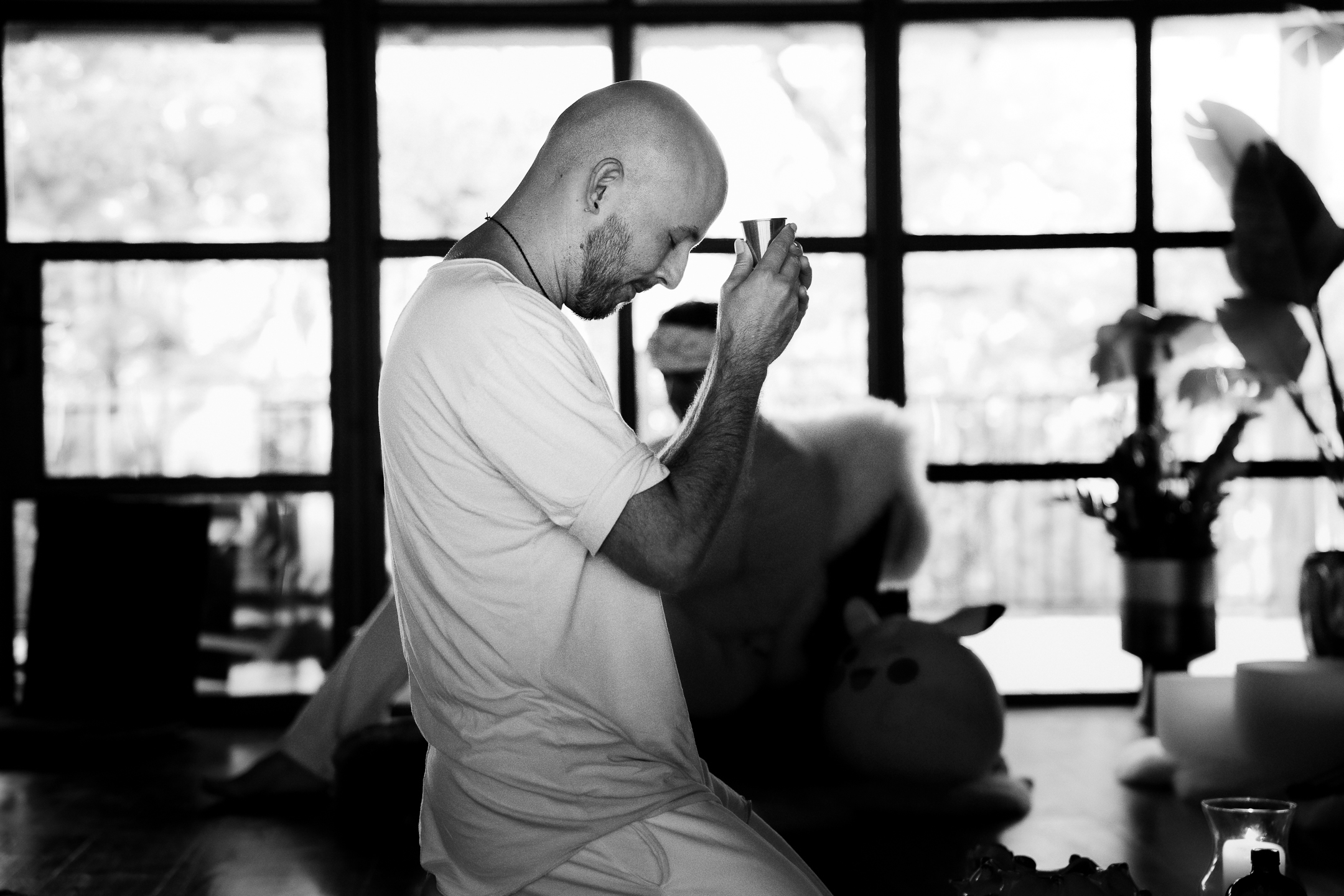 A man kneeling in prayer by a window