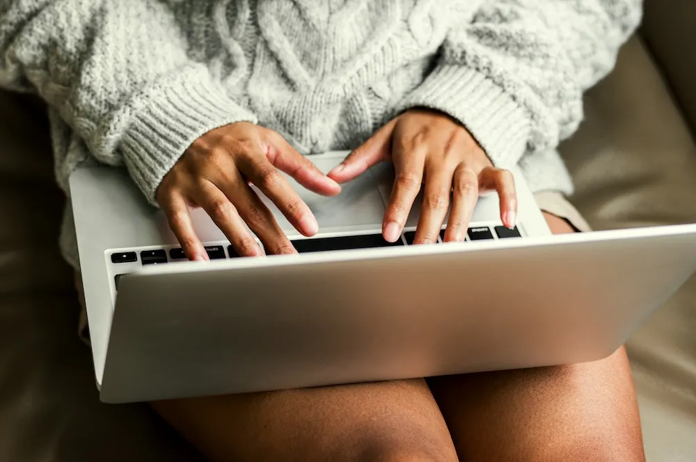An image of a woman on her laptop, signing up for a Clume Health program.