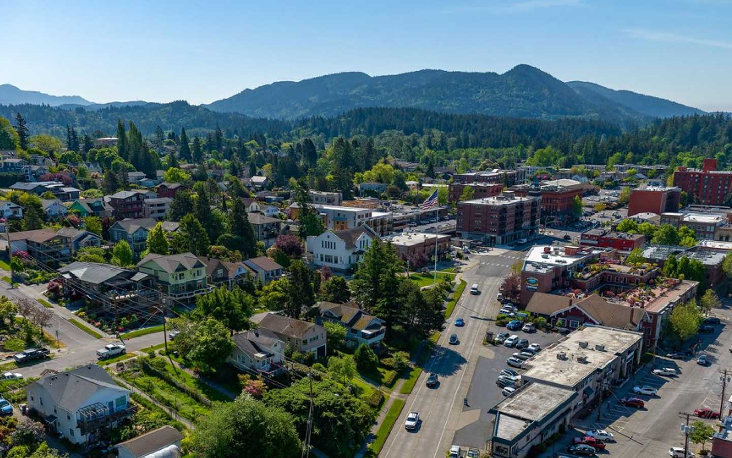 Aerial view of Bellingham, Washington, with neighborhood homes and downtown buildings against forested hills