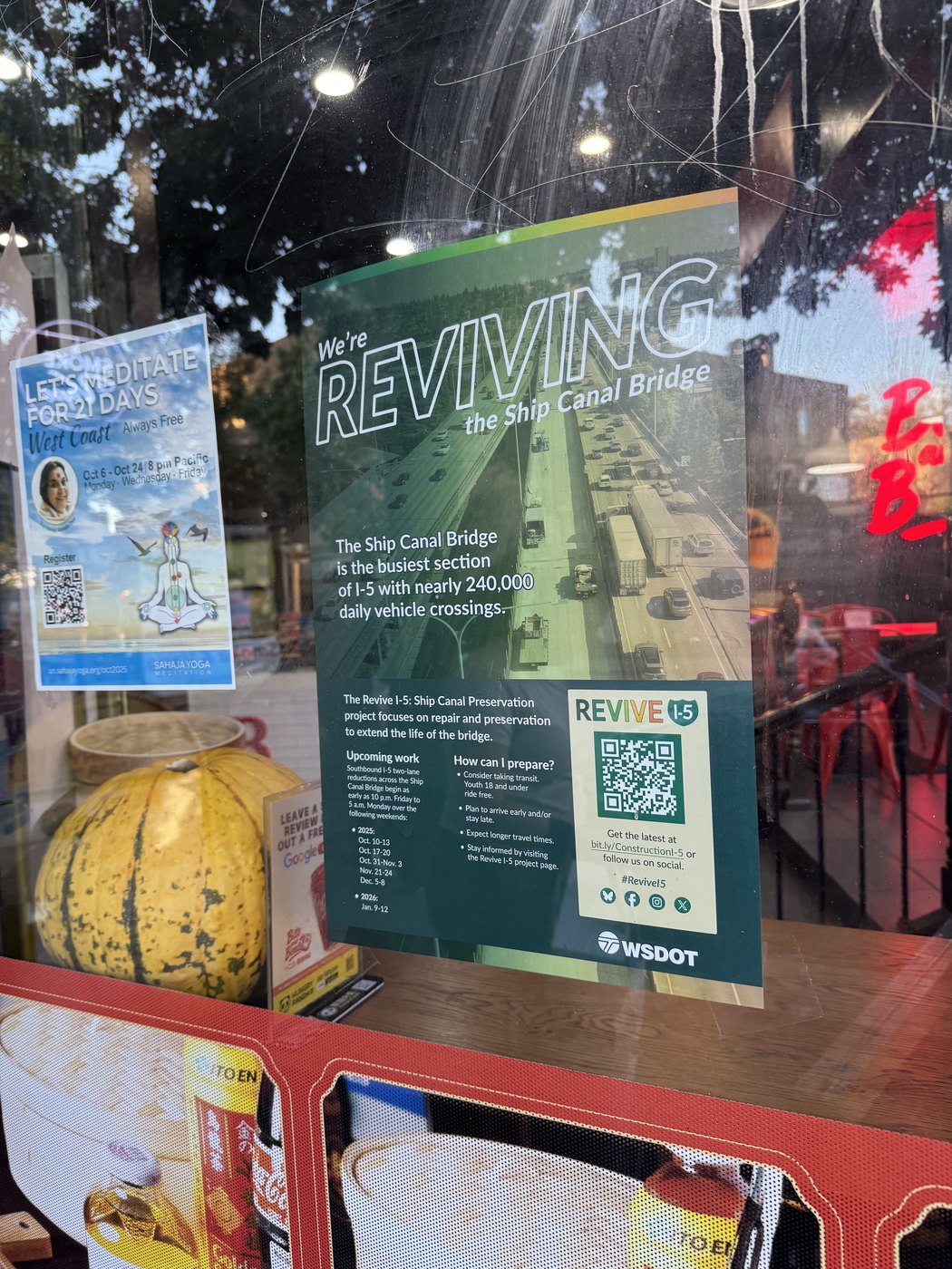 A Revive I-5 project poster displayed in the window of a neighborhood business
