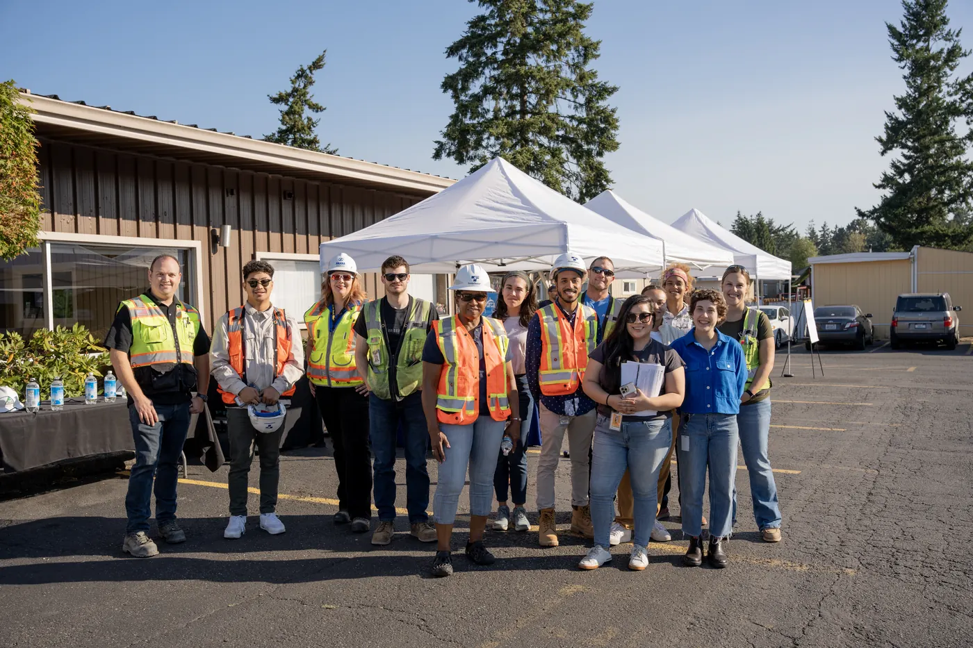 The Federal Way Link Extension outreach team stands together in safety vests in front of the community event tents.