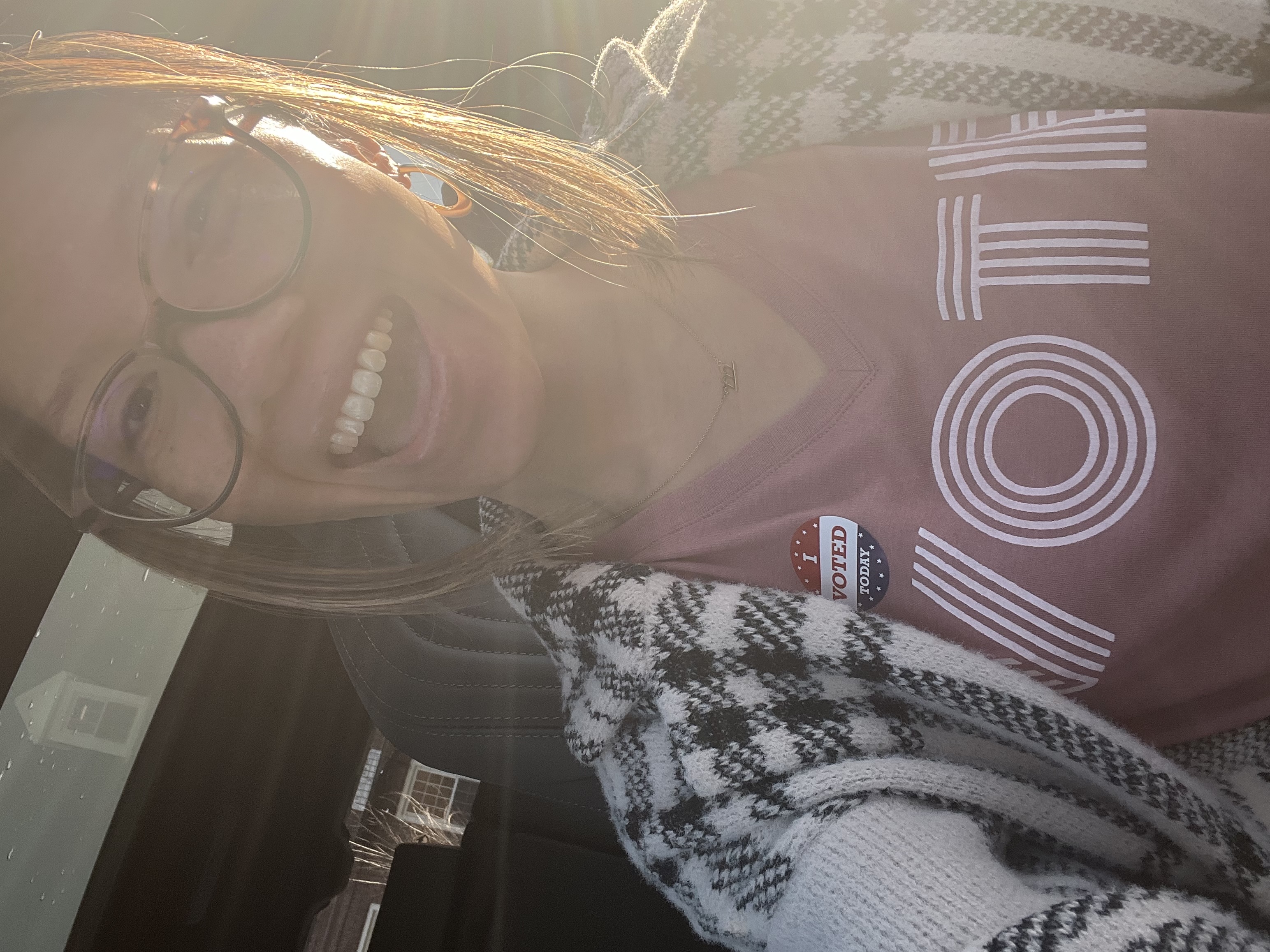 Close-up selfie of a smiling team member wearing a VOTE shirt
