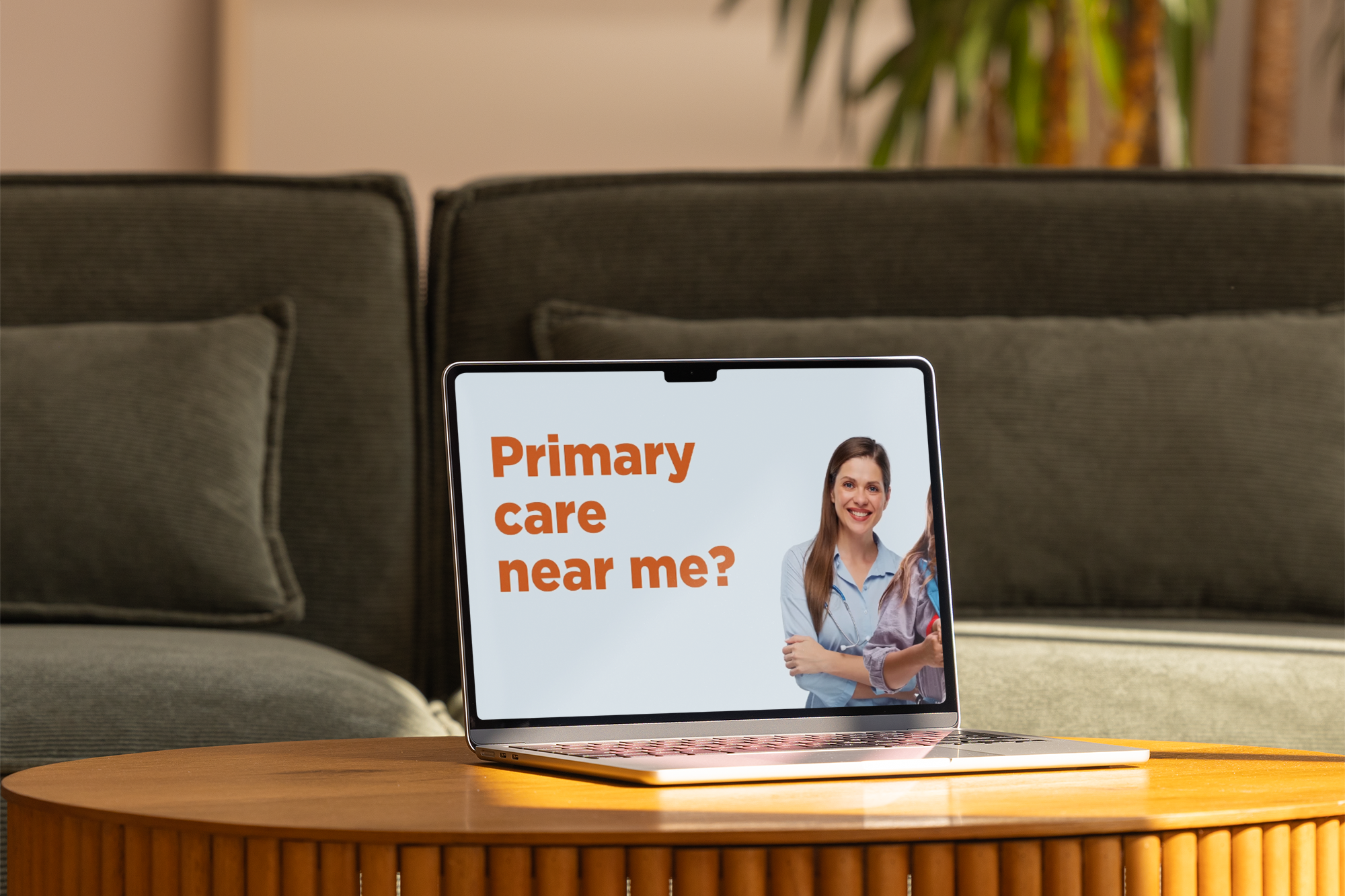 Laptop on a coffee table showing a North Shore Community Health ad that asks, Primary care near me?