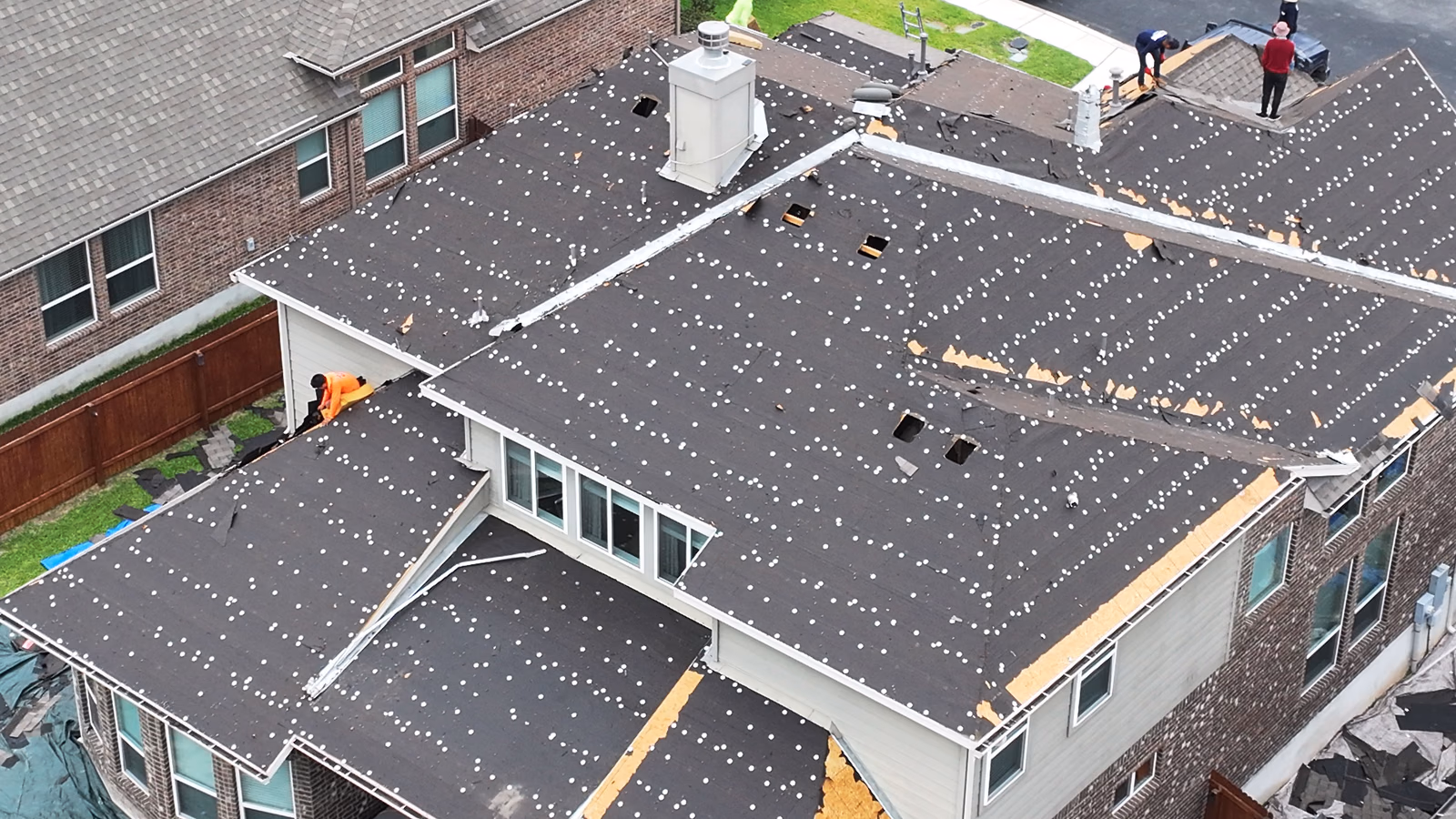 Roofing crew working together on a residential roof re-deck.