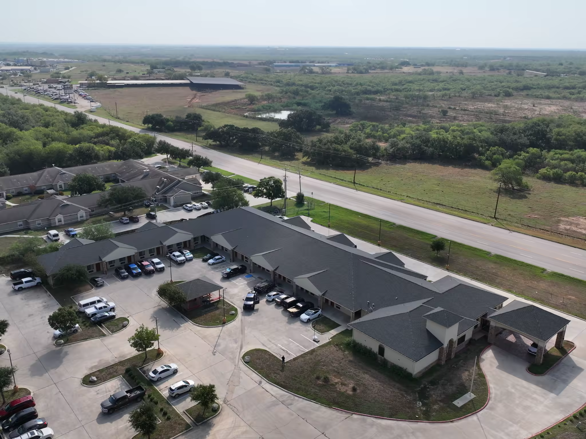 Wide aerial view of the completed Sunbridge Inn & Suites roof and surrounding property