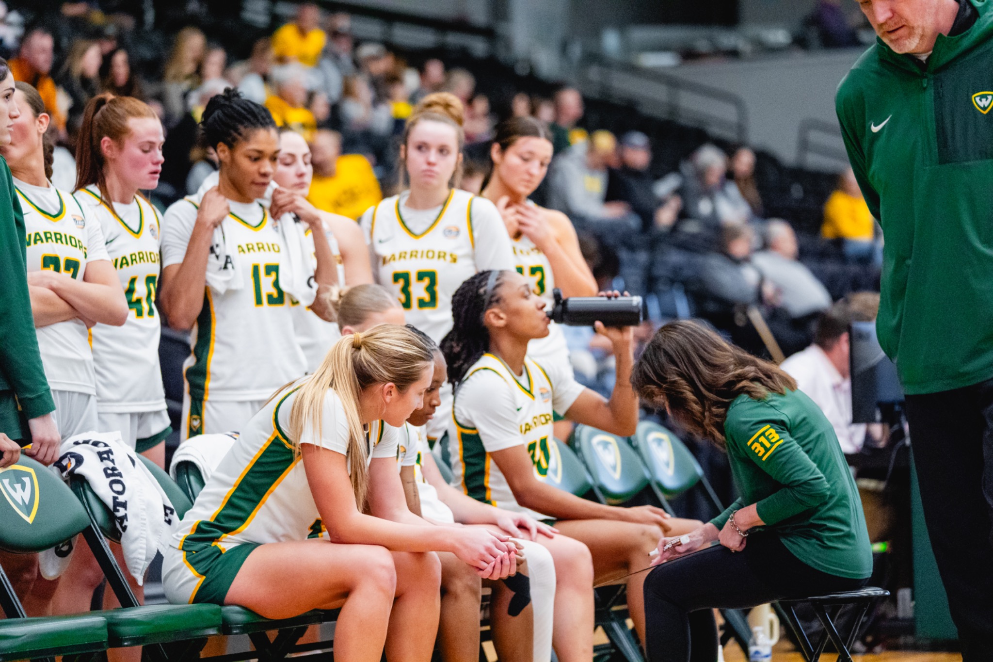 Wayne State women’s basketball players gather during a timeout.