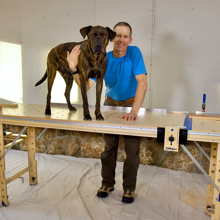 Man with a workbench with a dog standing on top