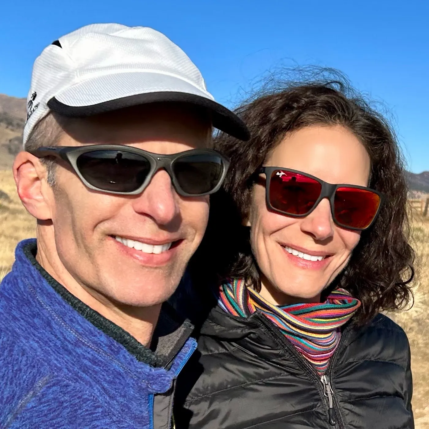 Man and women smiling with sunglasses on