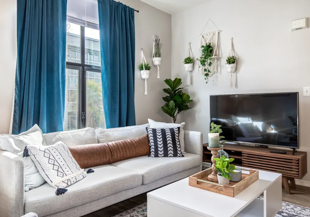 Living area with sofa, large window, coffee table, and tv