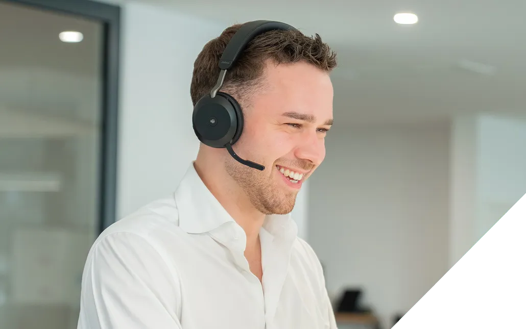Lächelnder Mann mit Headset in einem modernen Büro.