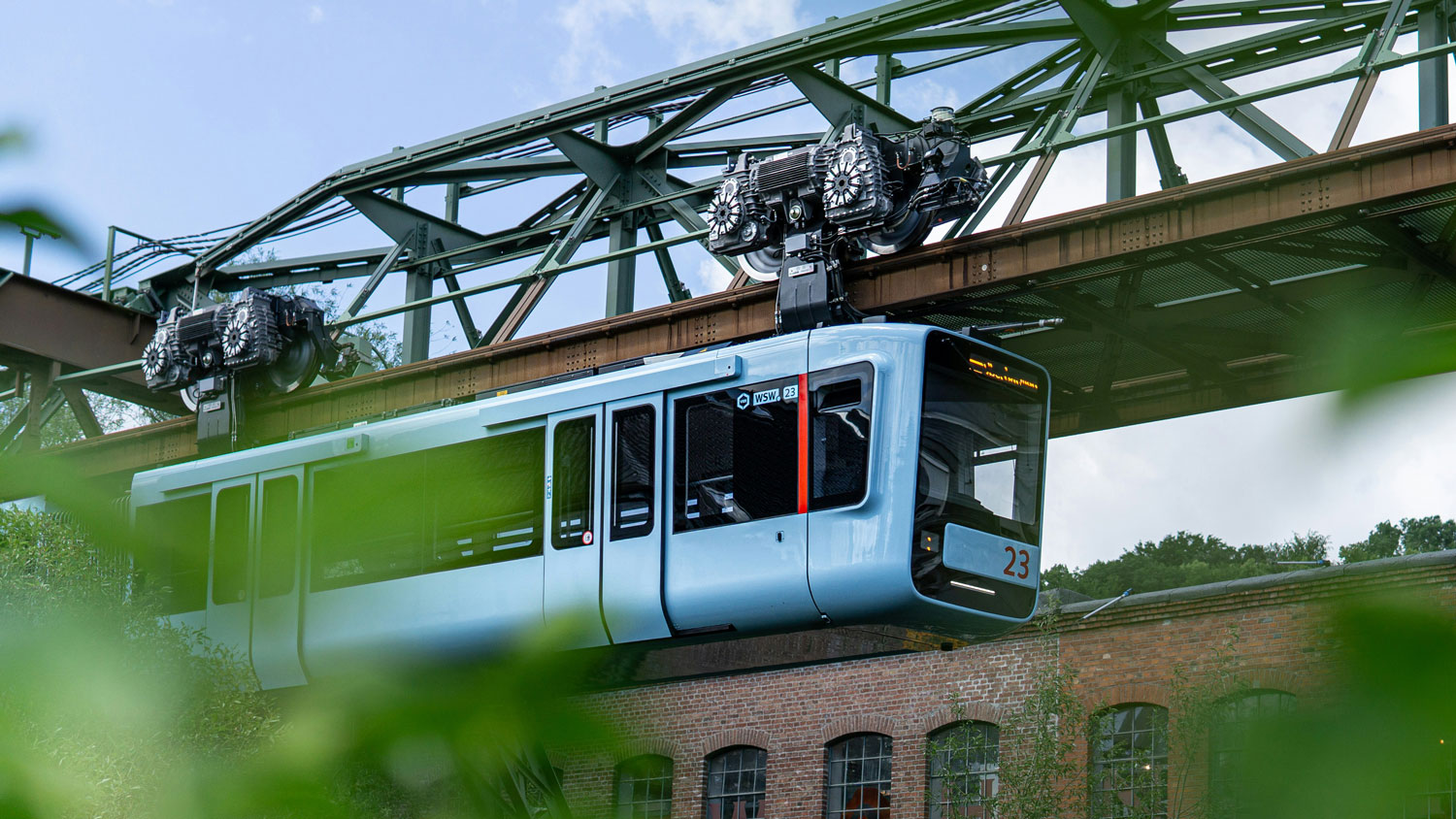 Wuppertaler Schwebebahn an ihrem grünen Stahlgerüst.