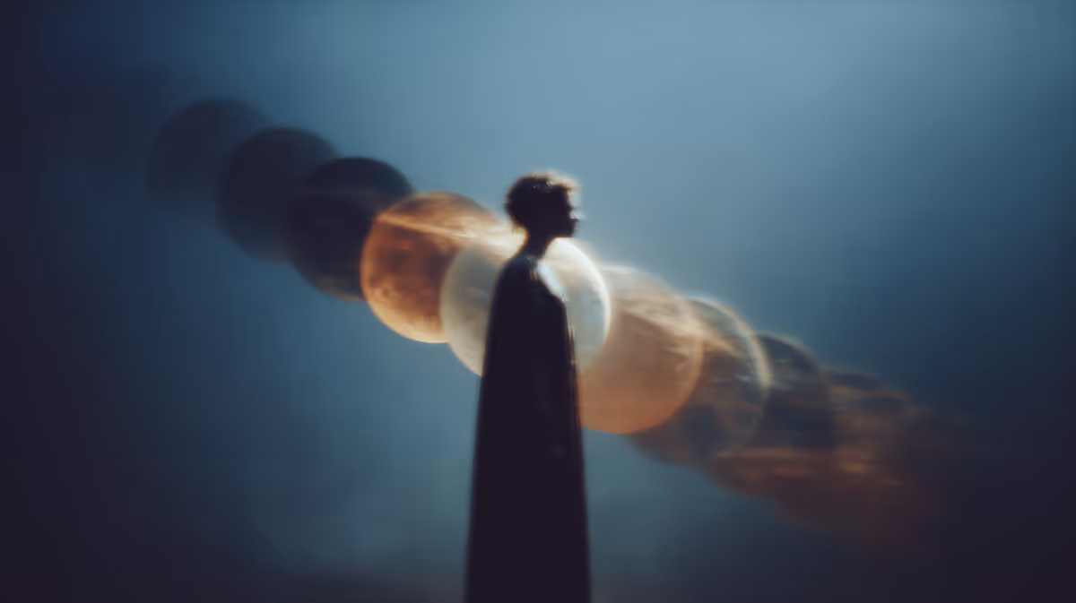 Silhouette of a person with multiple shadowy orbs behind them against a blue misty background.