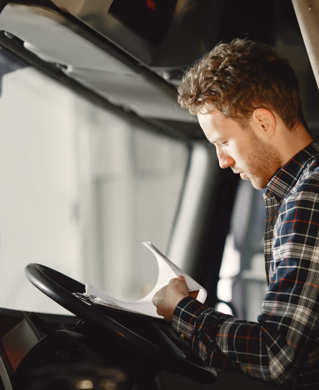 Convoyeur consultant les documents de prise en charge au volant d'un véhicule