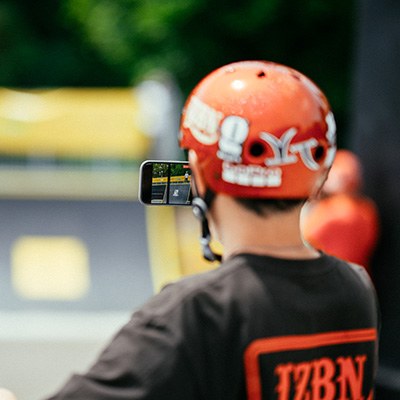 Une personne de dos, filmant un skateboarder sur une rampe du NL Contest à Strasbourg.