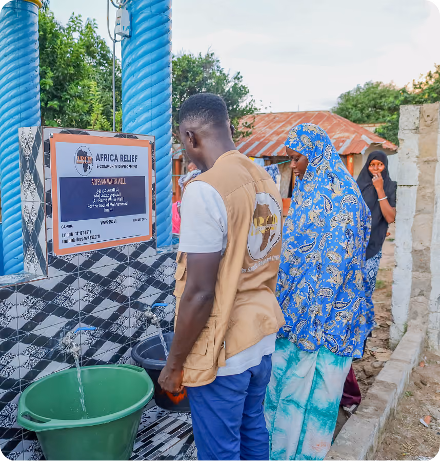 Community members filling buckets at the Al-Hamd Water Well in The Gambia, an ARCD artesian well dedicated for the soul of Mohammed Imam.