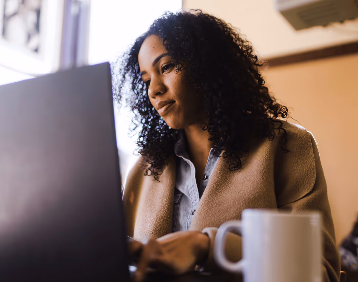 A Woman Sitting Behind a Laptop - Photo