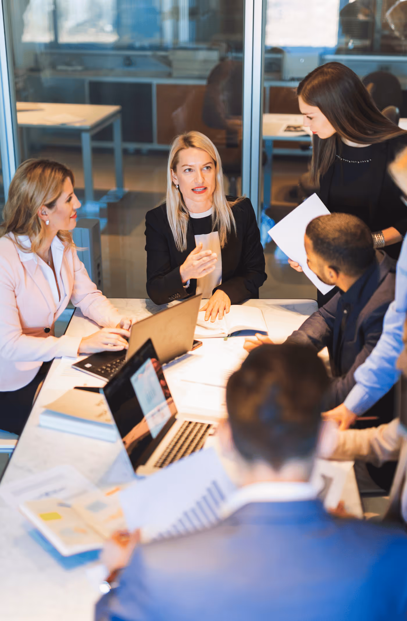 A Woman Talking to Other Team Members During the Meeting - Photo
