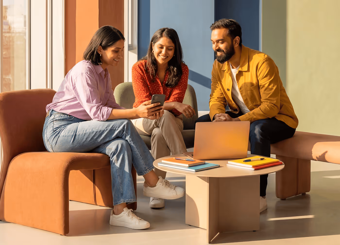 Three Smiling People Having a Small Meeting in a Room- Photo