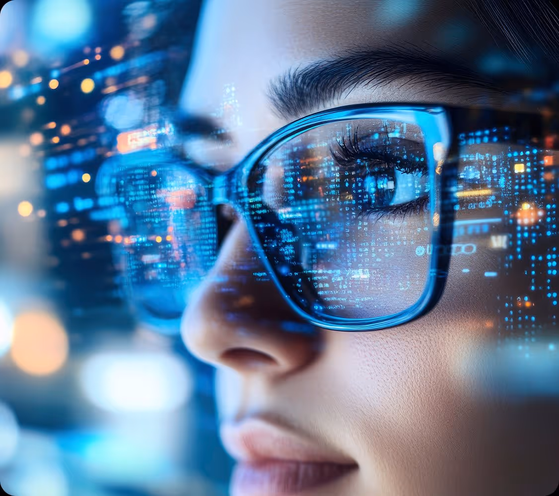 Close-up of a person's face wearing glasses reflecting blue digital code and data lights.