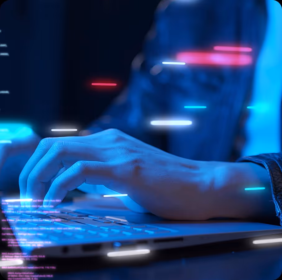 Close-up of hands typing on a laptop keyboard with blue lighting and digital code effects.