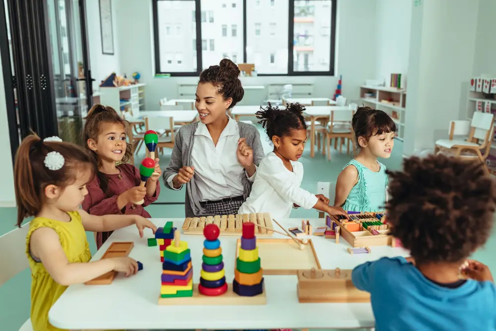 Nursery practitioner playing with children and toys