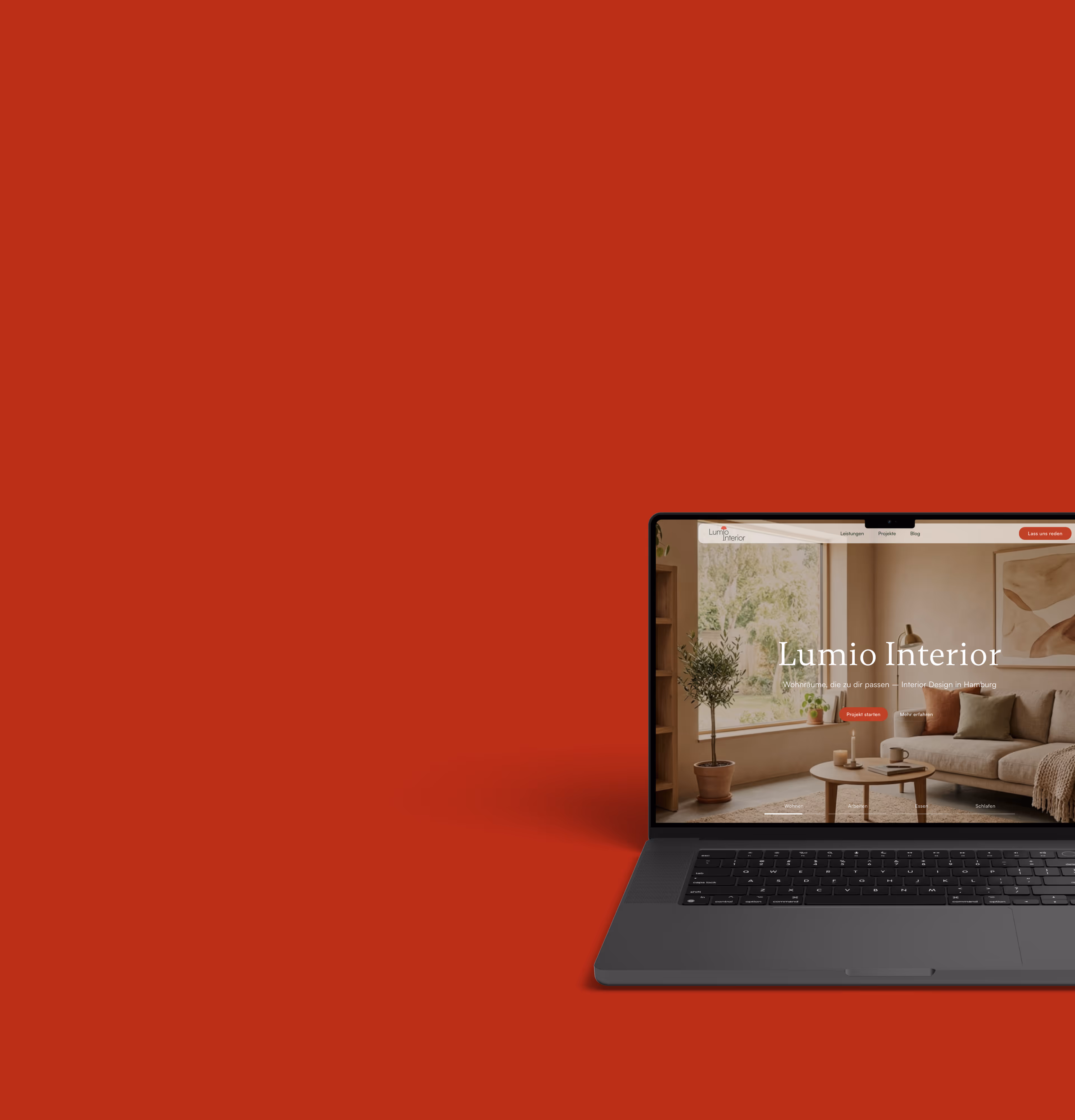 Laptop zeigt Lumio Interior Website mit modern gestaltetem Wohnzimmer auf rotem Hintergrund.