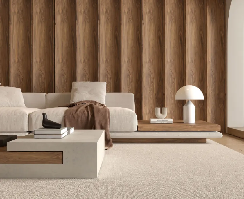 Modernes Wohnzimmer mit cremefarbener Couch, brauner Decke, minimalistischer weißer Lampe auf hölzernem Beistelltisch und Holzwand im Hintergrund.