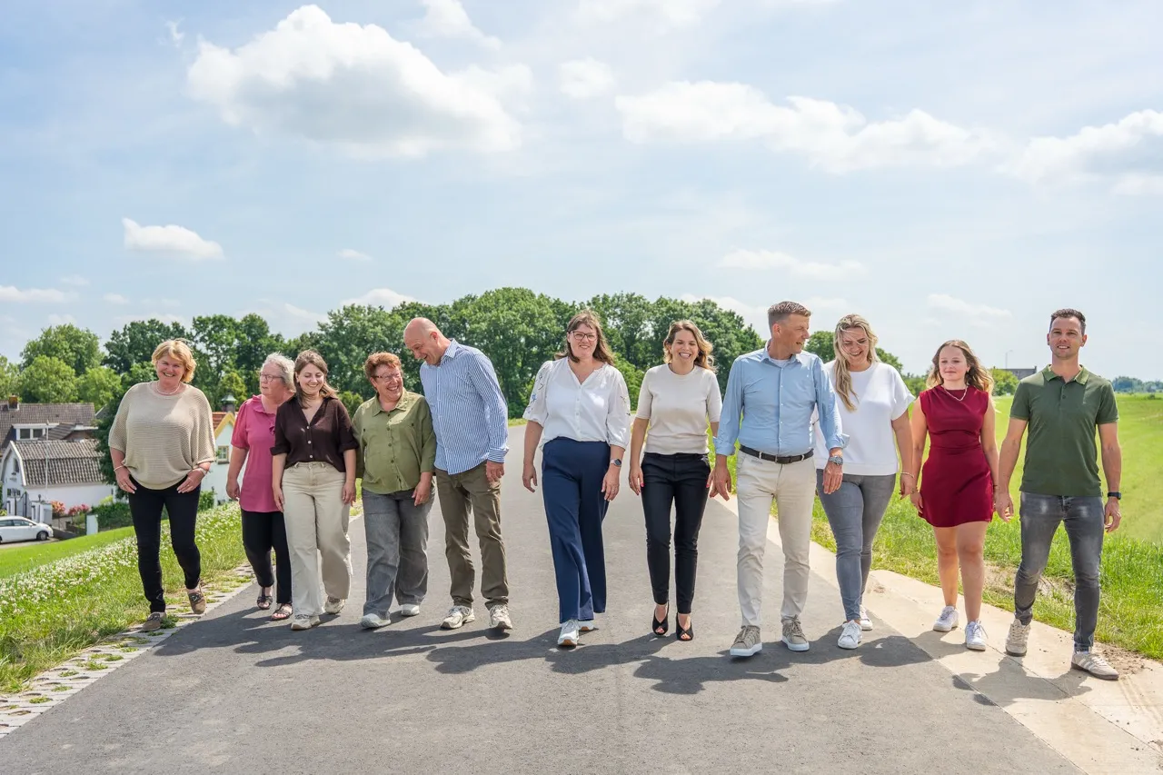 Het team van Satter Assurantiën wandelt over een dijkweg in het rivierenlandschap bij Haaften