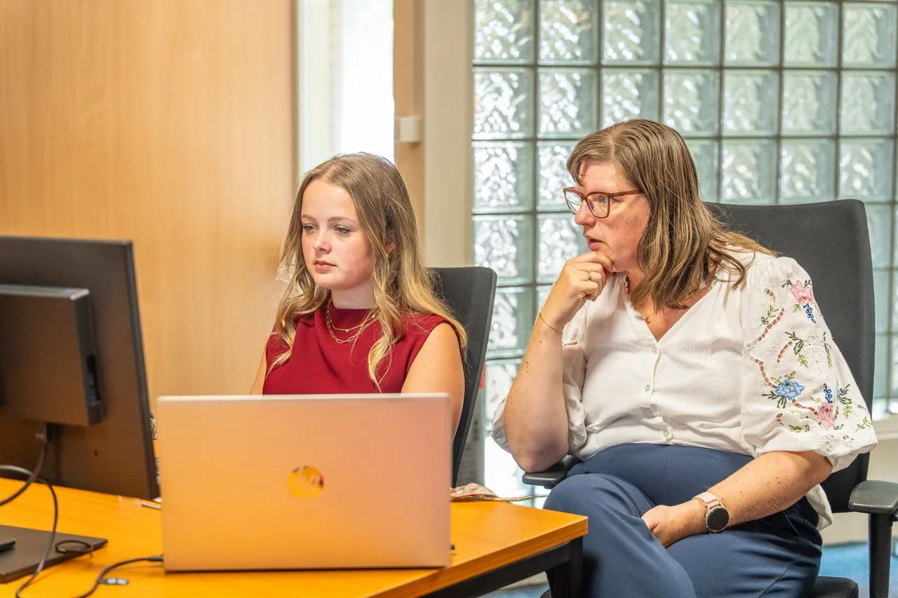Adviseur van Satter Assurantiën kijkt samen met een klant mee op de laptop