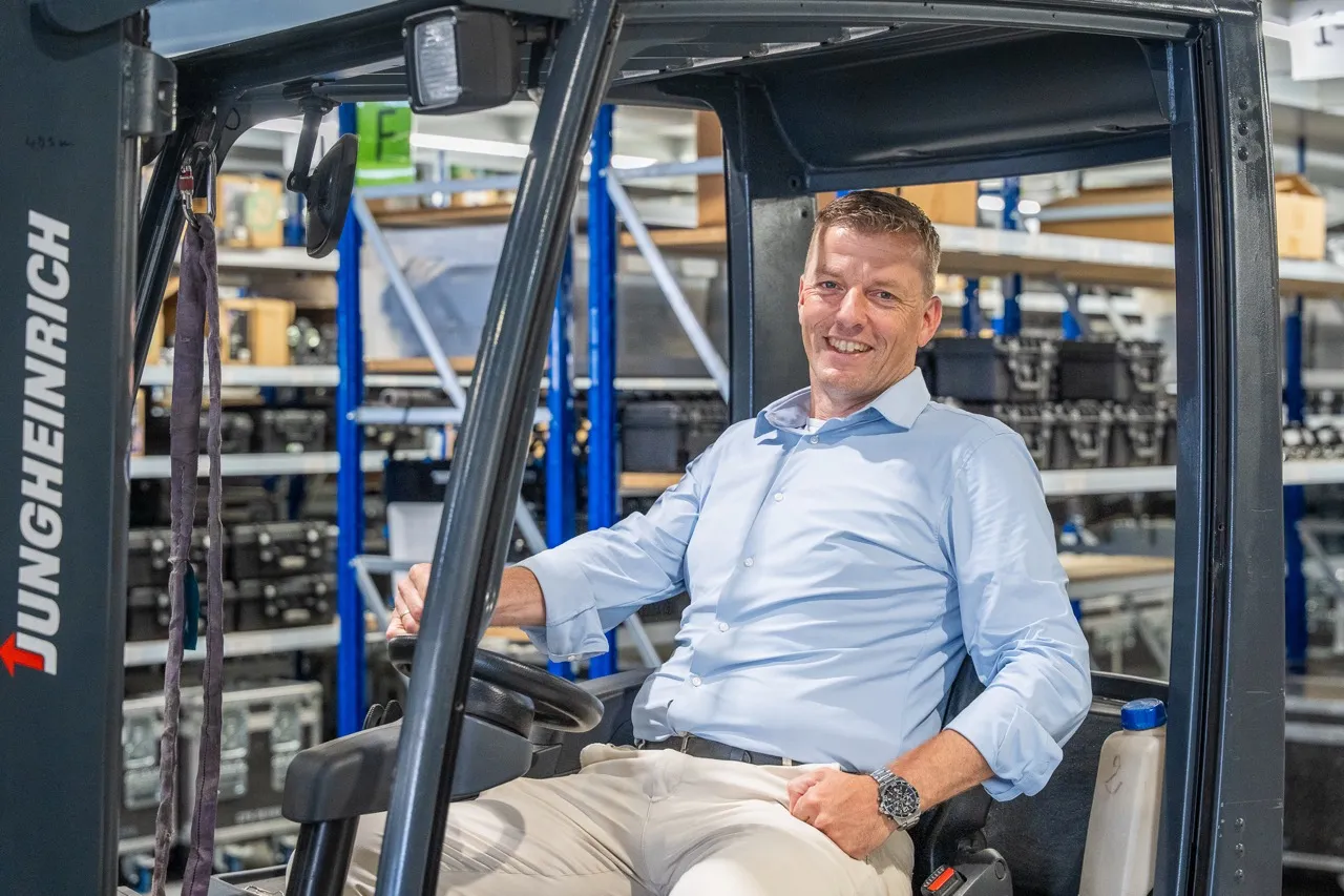 Ondernemer op een heftruck in zijn magazijn, zakelijk verzekerd via Satter Assurantiën