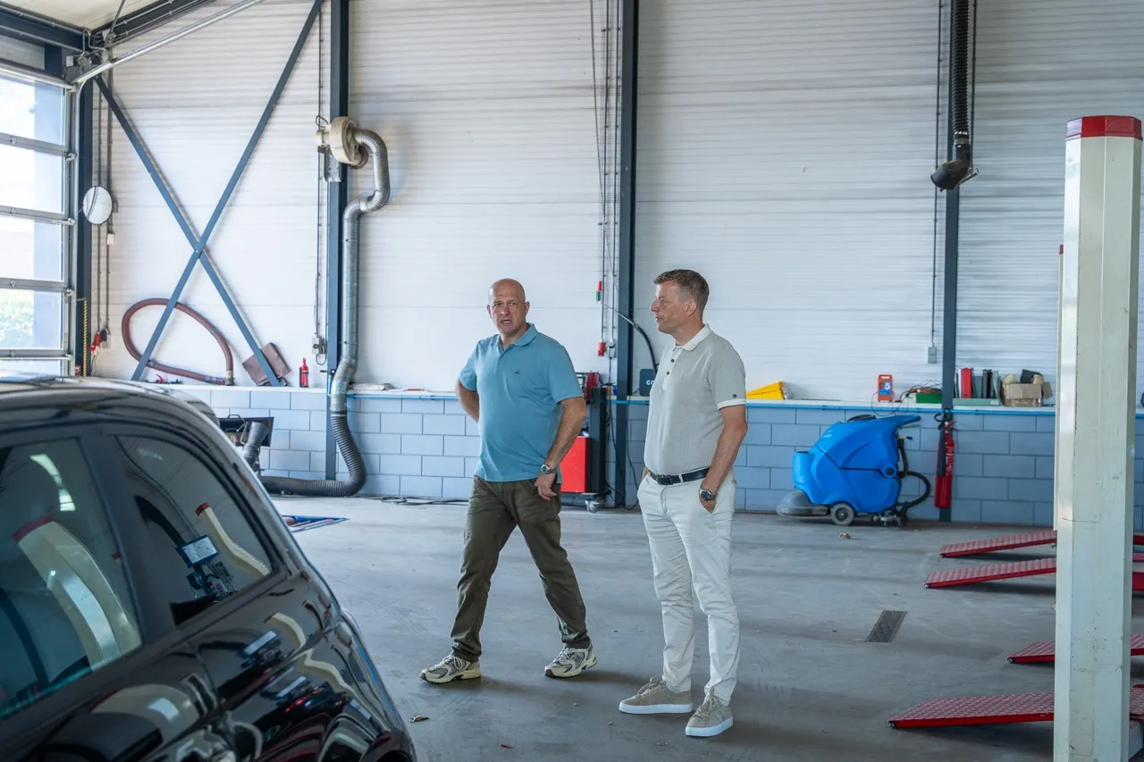Adviseur van Satter Assurantiën bekijkt samen met de ondernemer de werkplaats van een autobedrijf