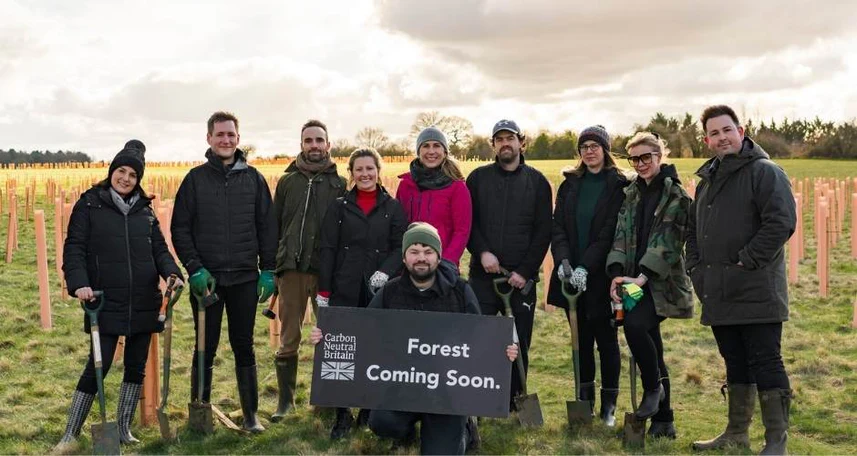 group of people holding "forest coming soon" sign