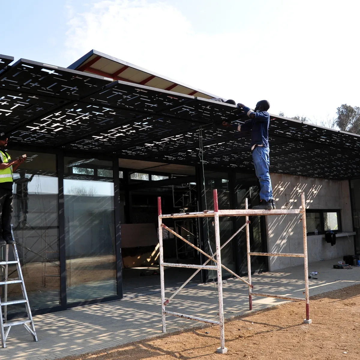 Laser-cut roof panels being installed on site
