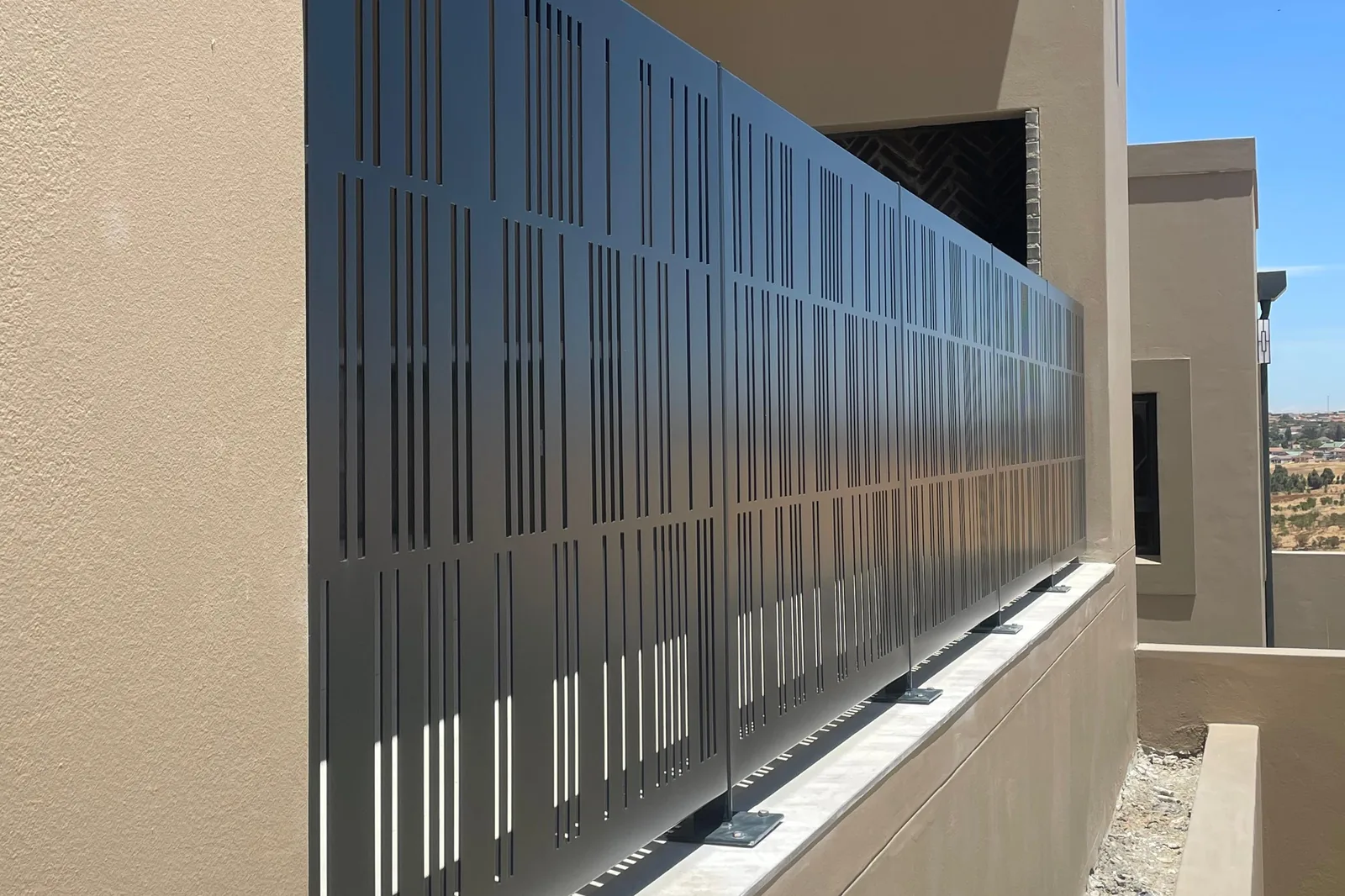 Run of perforated aluminium balustrade panels fixed on base plates, residential project, Malmesbury