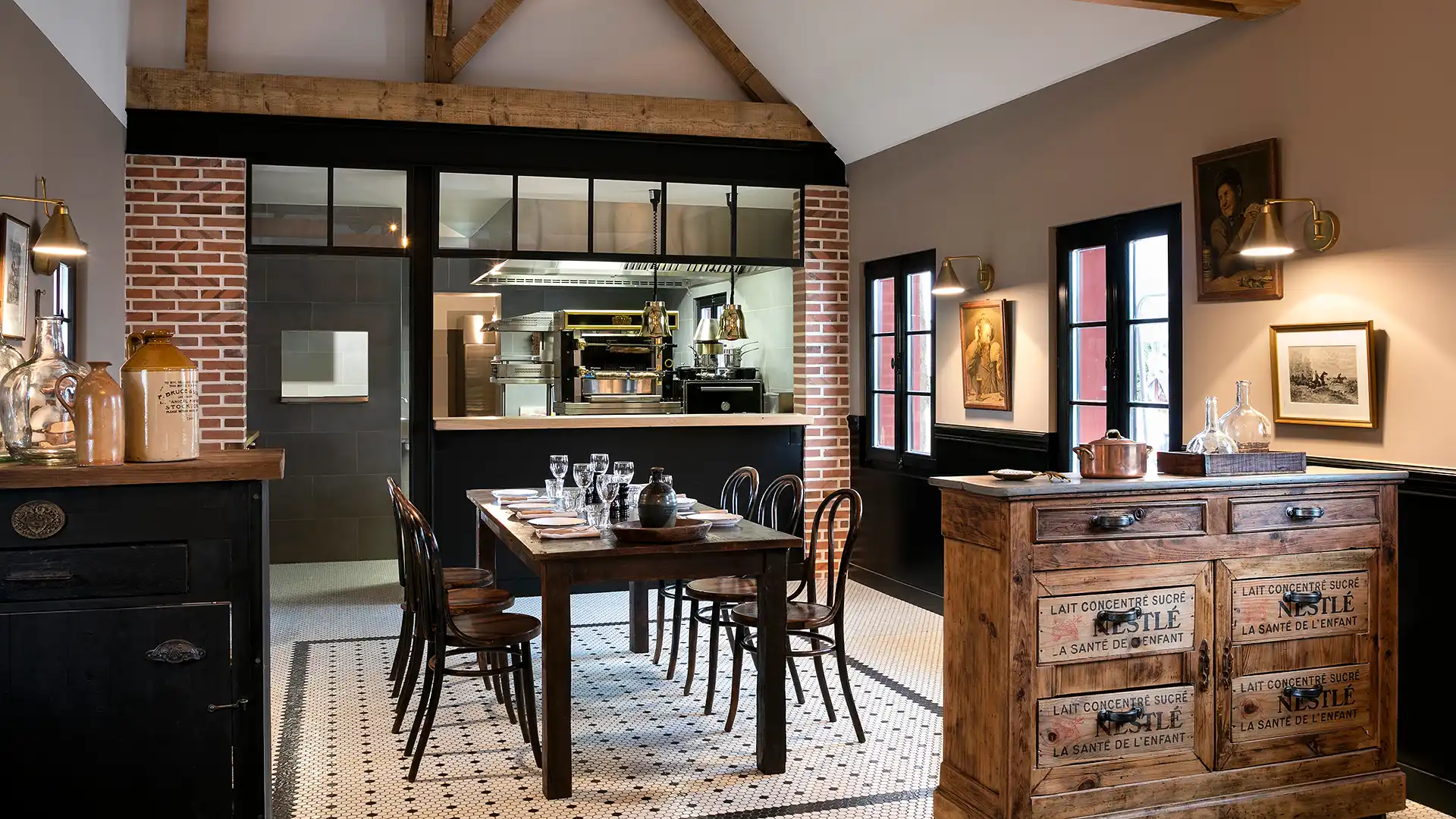 Rustic dining room with wooden table, chairs, patterned tiling, and vintage Nestlé furniture.