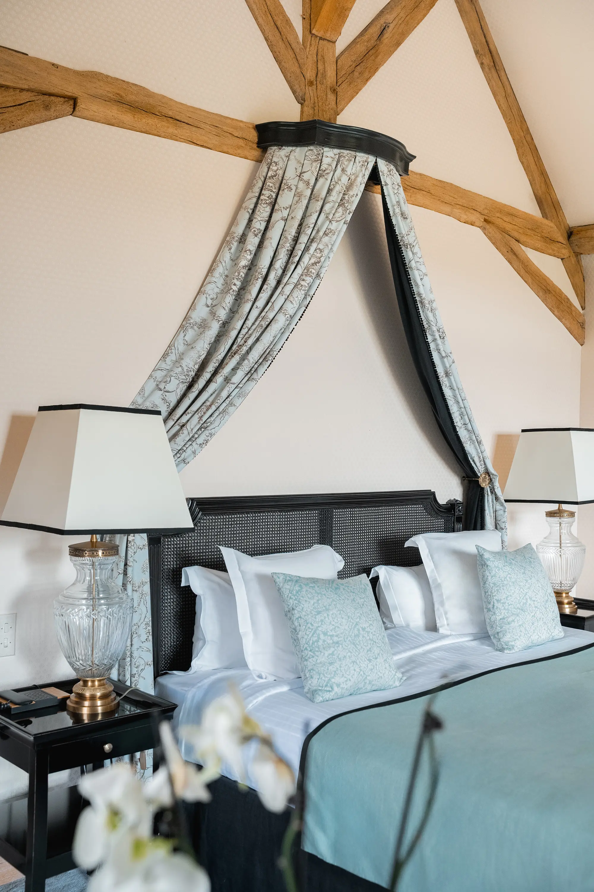 Chambre élégante avec grand lit, têtes de lit en noir, coussins bleus et lampes de chevet en verre, Les Hauts de Loire, hôtel de luxe 5 étoiles à Veuzain-sur-Loire,
Vallée de la Loire, France.