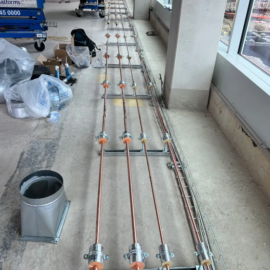 Copper heating pipework installation across a commercial building floor prior to screed and final fit-out.