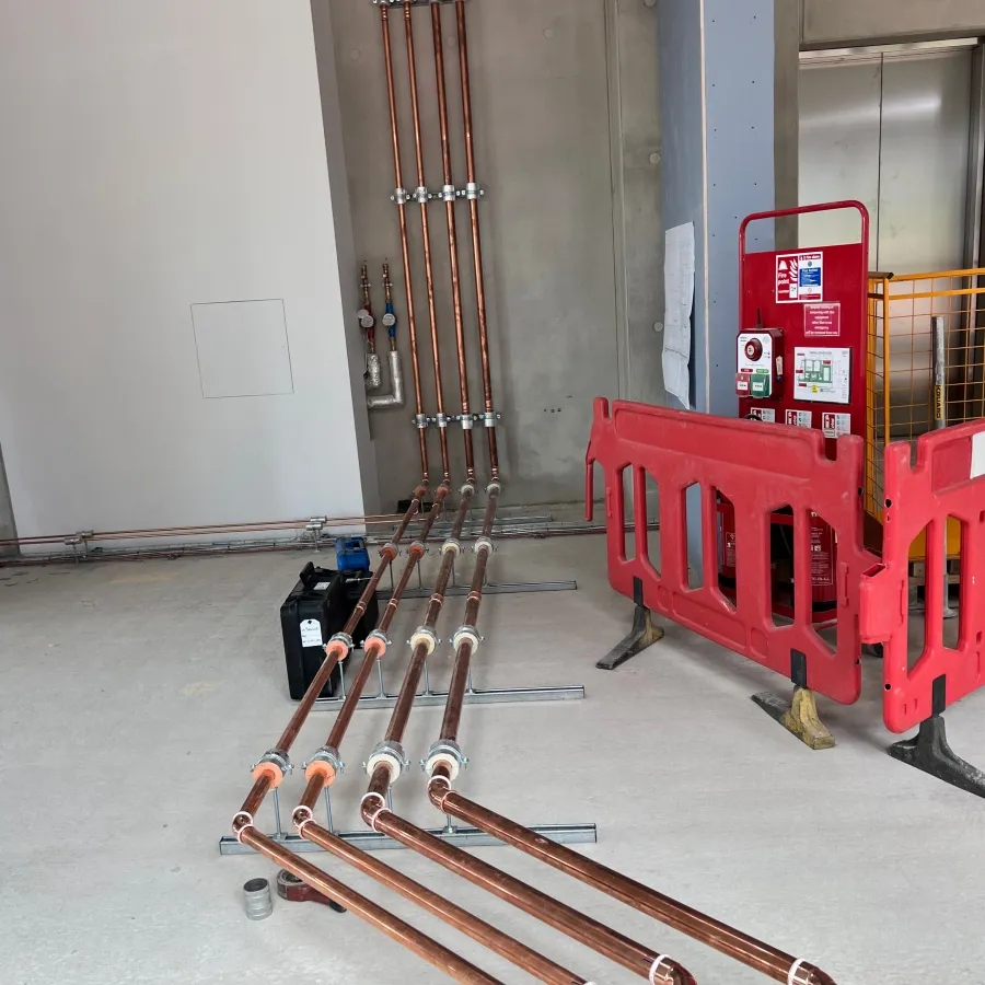 Commercial heating pipework installation with neatly routed copper services ready for connection.