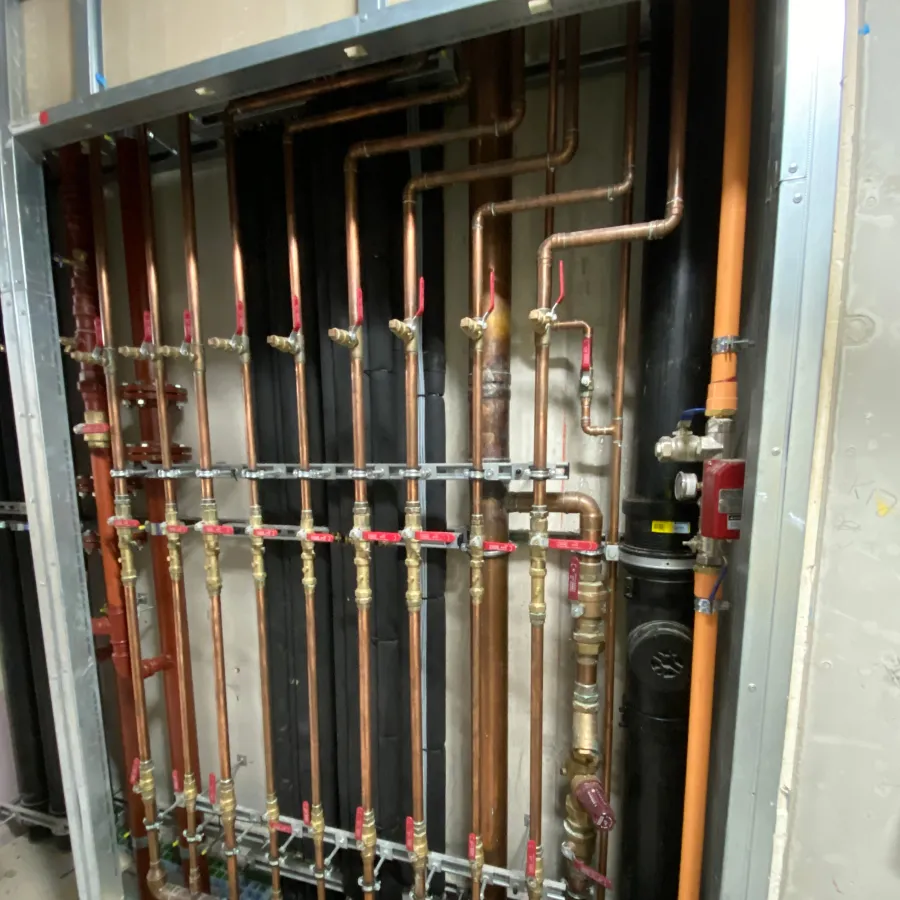 Commercial plant room with insulated pipework and heating system distribution manifold installation.