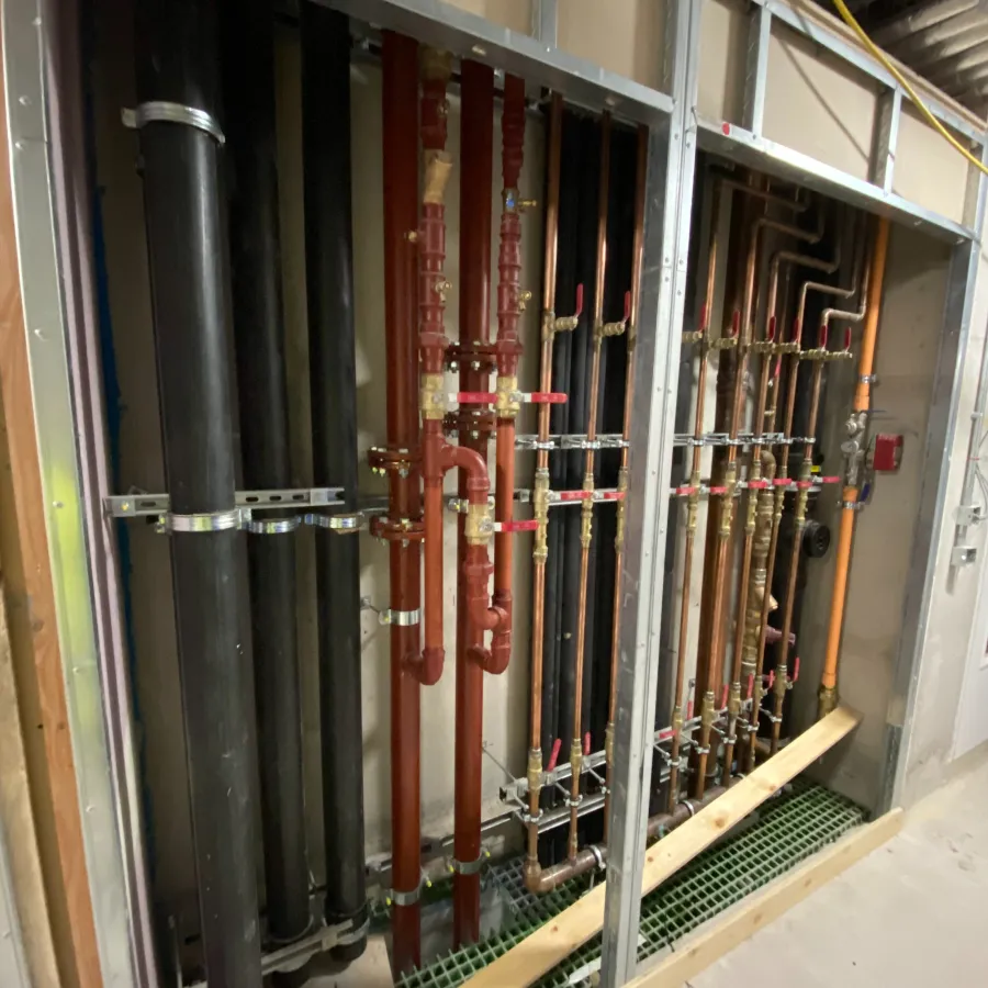 Commercial mechanical services installation featuring insulated pipework, valves and heating distribution systems.