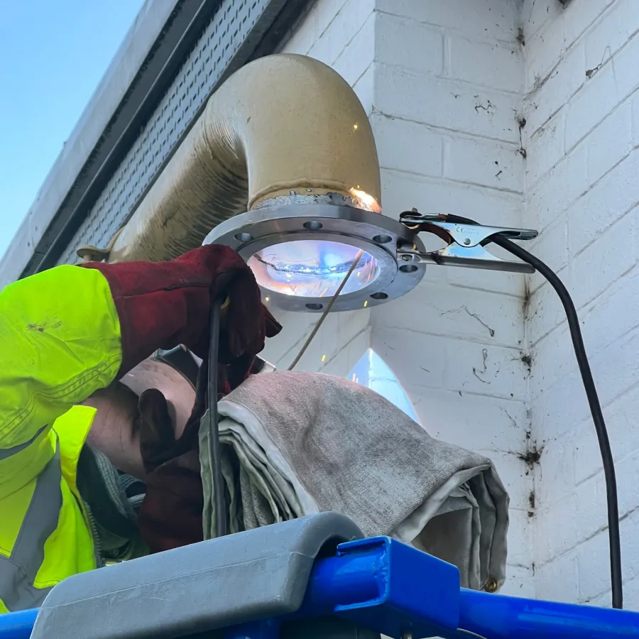 Engineer welding commercial gas pipework during an industrial gas installation project.