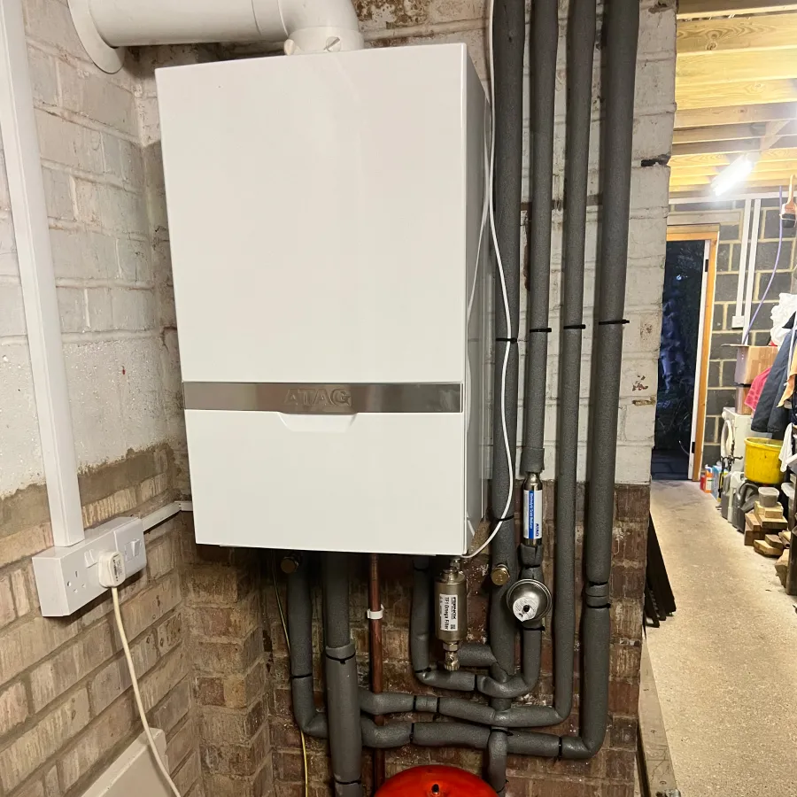 Completed wall-mounted boiler installation with insulated pipework and professional heating system finish.