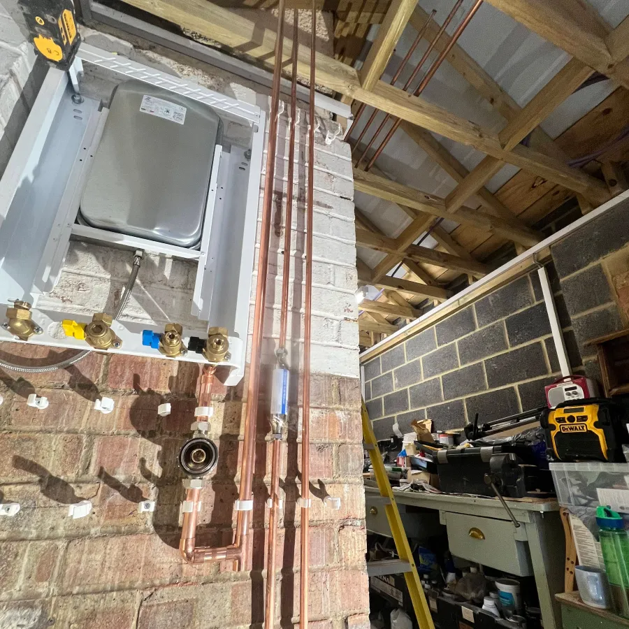New copper pipework installation for a domestic boiler replacement in a residential garage.