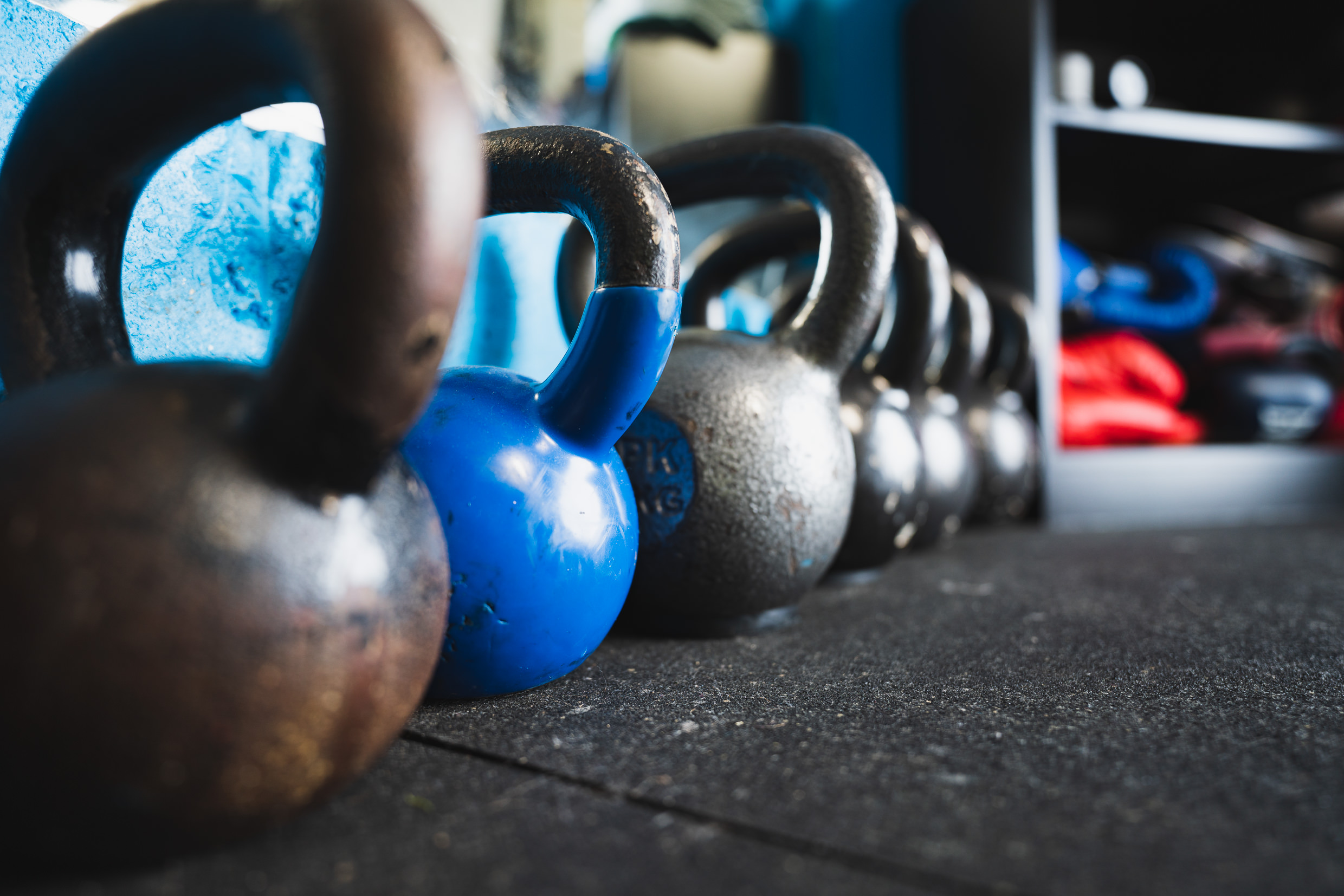 Row of cast iron kettlebells lined up on the gym floor