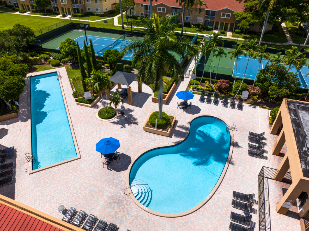 Swimming pools with tennis courts and palm trees