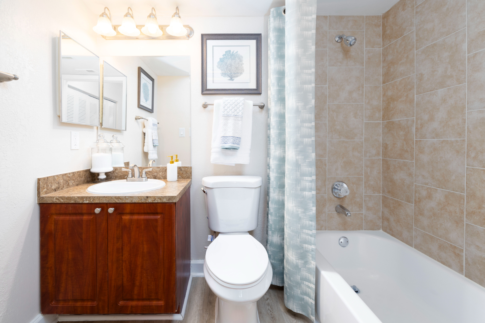 Bathroom with shower tub combo and brown cabinets