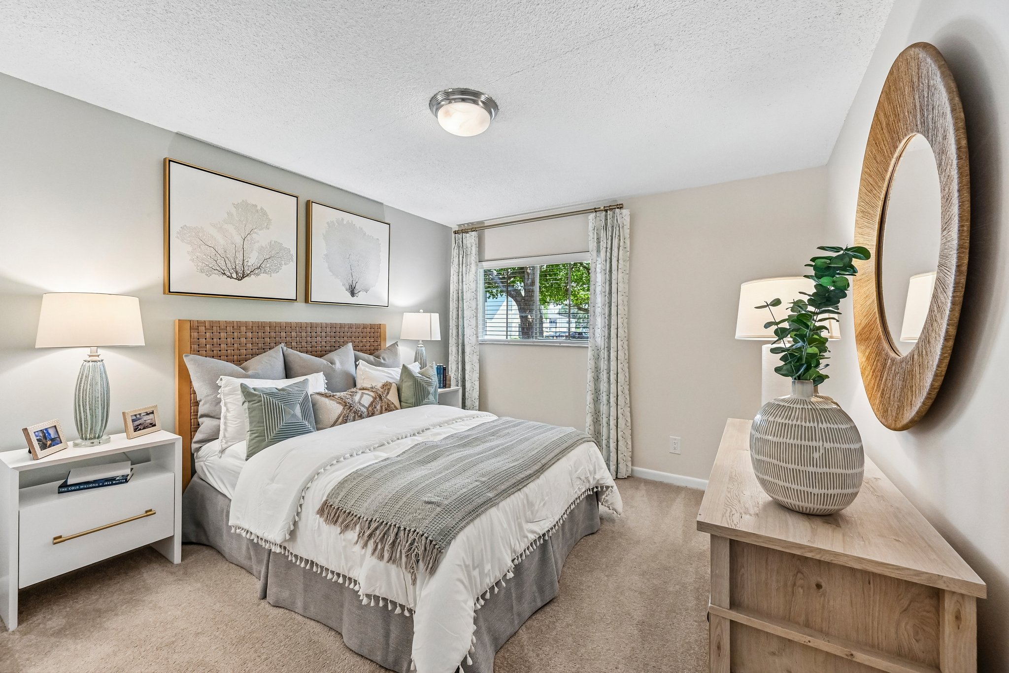 Bedroom with bed, dresser, and large window Azalea Village